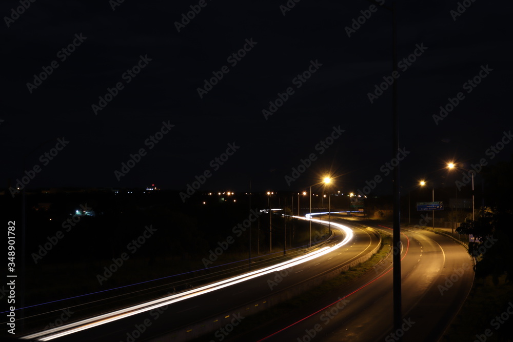 Obraz premium Luzes de carros a noite na estrada