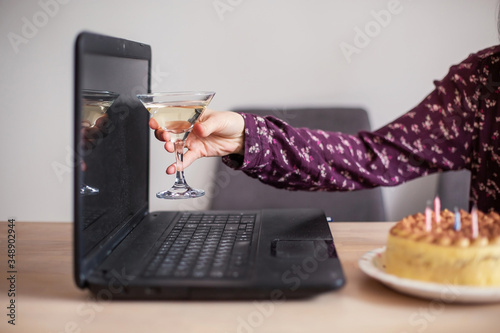 online alcoholism. Toast with a laptop over the internet close-up. Self-isolation distance solitude quarantine. Alcohol glass wine drink videoconference telecommunications technology cheers photo
