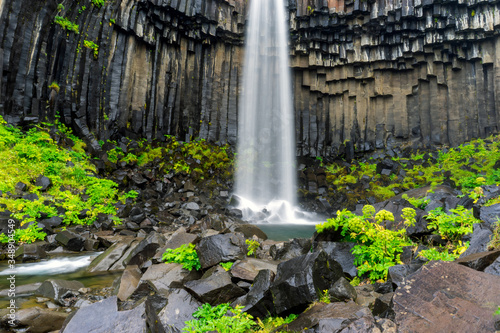 Svartifoss waterfall and basalt columns shaped over the years in the skaftafell national park in the icelandic highlands. Texture, holiday and travelling concept.