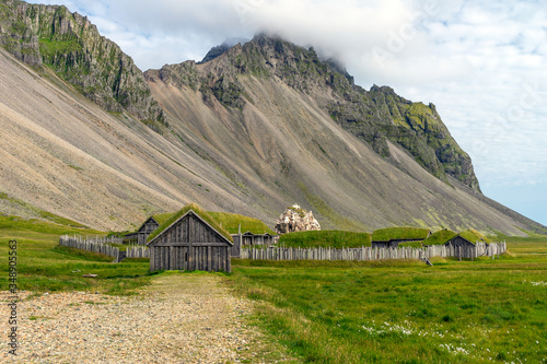 Old and ancient viking village used for film set infront of the Vestrahorn mountain chain in Stokksnes in Iceland. Vikings, warriors and traditional architecture concept.