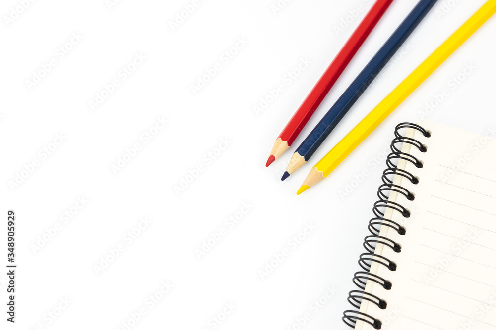color pencils and notebooks placed on a white background in the home studio. This concept is used as an illustration for education idea color pencils and notebooks placed on a white background in the home studio. This concept is used as an illustration for education idea