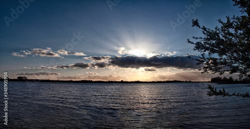 Sunset panorama, beam over cloud, above lake, sun rays over clouds, scenic evening with sun