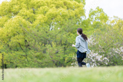 自然豊かな公園をランニングする若い女性 © west_photo