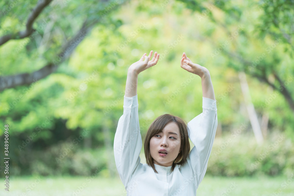 緑あふれる公園でくつろぐ女性