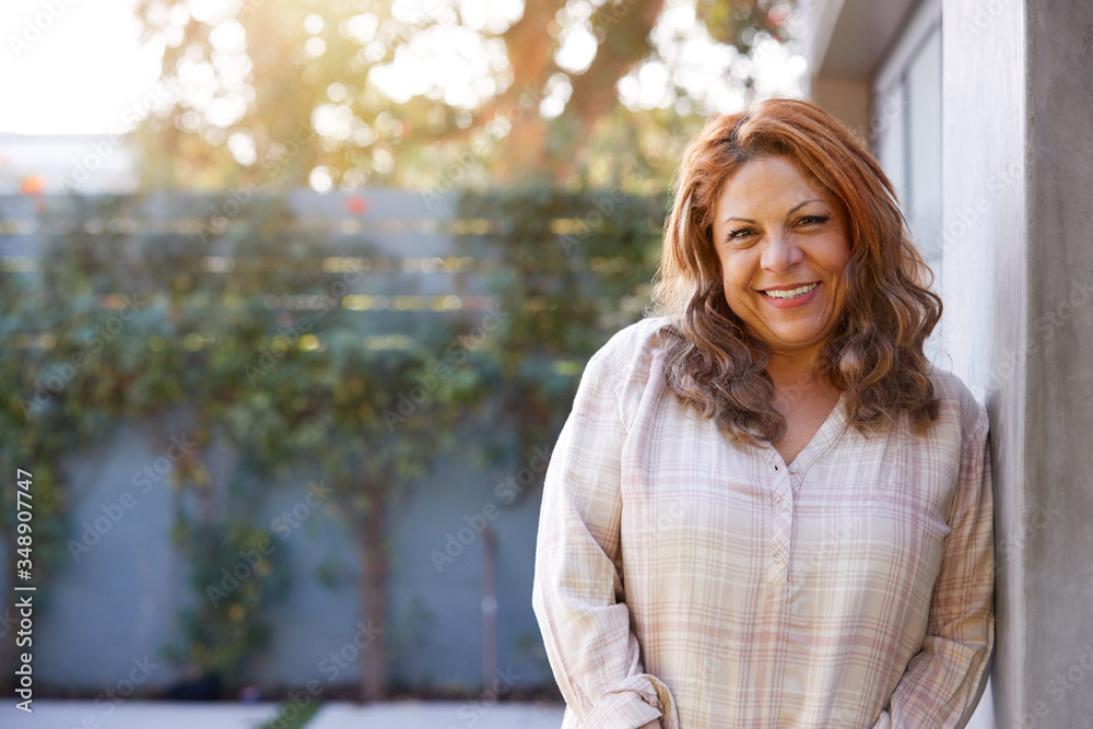 Portrait Of Smiling Senior Hispanic Woman In Garden At Home Against Flaring Sun Portrait Of Smiling Senior Hispanic Woman In Garden At Home Against Flaring Sun
