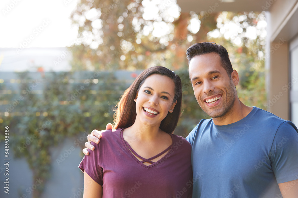 Portrait Of Smiling Hispanic Couple Relaxing In Garden At Home Together Portrait Of Smiling Hispanic Couple Relaxing In Garden At Home Together