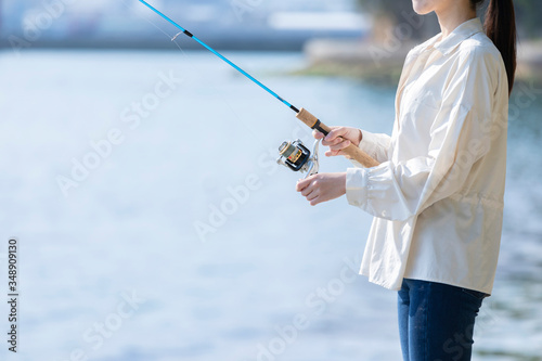 海辺で釣りを楽しむ若い女性