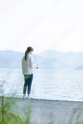 海辺で釣りを楽しむ若い女性