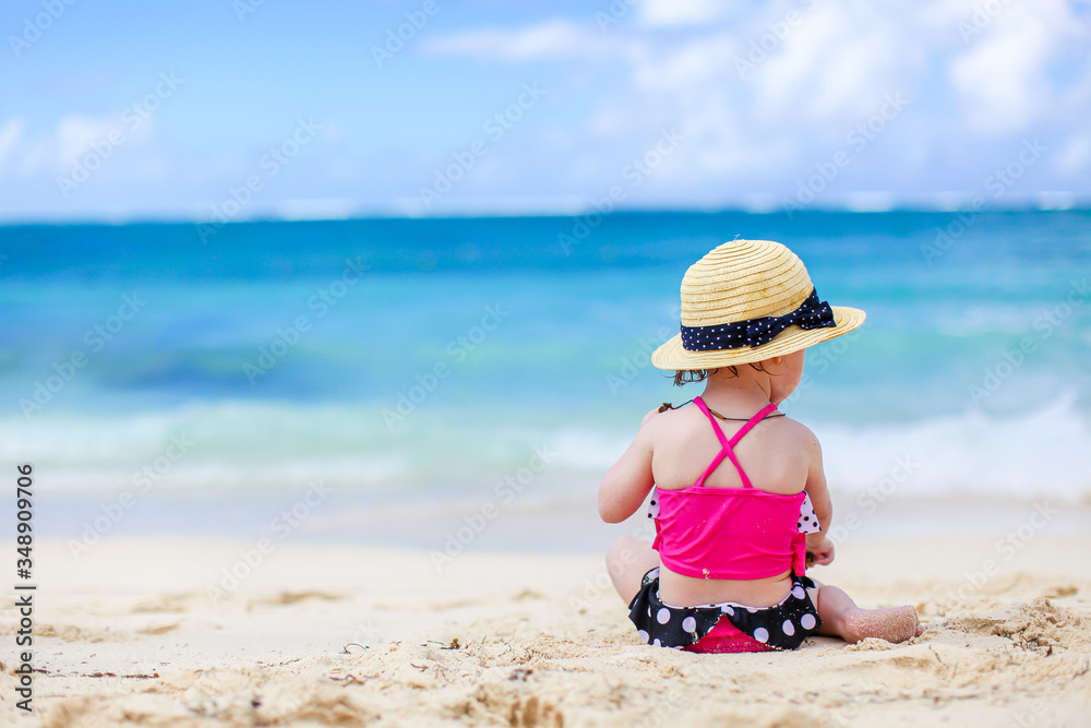 Little girl at tropical white beach making sand castle Little girl at tropical white beach making sand castle