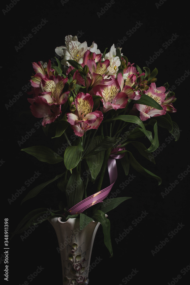 white and lilac flowers in a vase on a black background