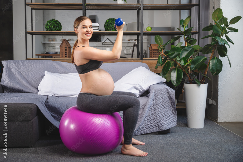 Fototapeta premium Pregnant woman is doing exercises with gymnastic ball
