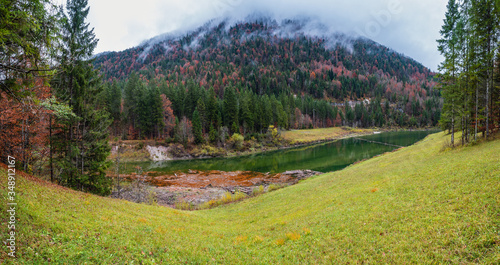 Alpine  Sylvenstein Stausee lake on Isar river, Bavaria, Germany. Autumn overcast, foggy and drizzle day. Picturesque traveling, seasonal, weather, and nature beauty concept scene. photo