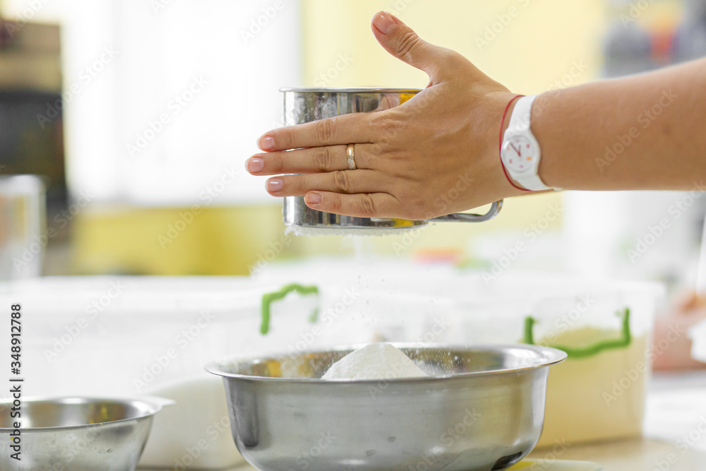 Cooking Baking. Cook sifts the flour close up Cooking Baking. Cook sifts the flour close up