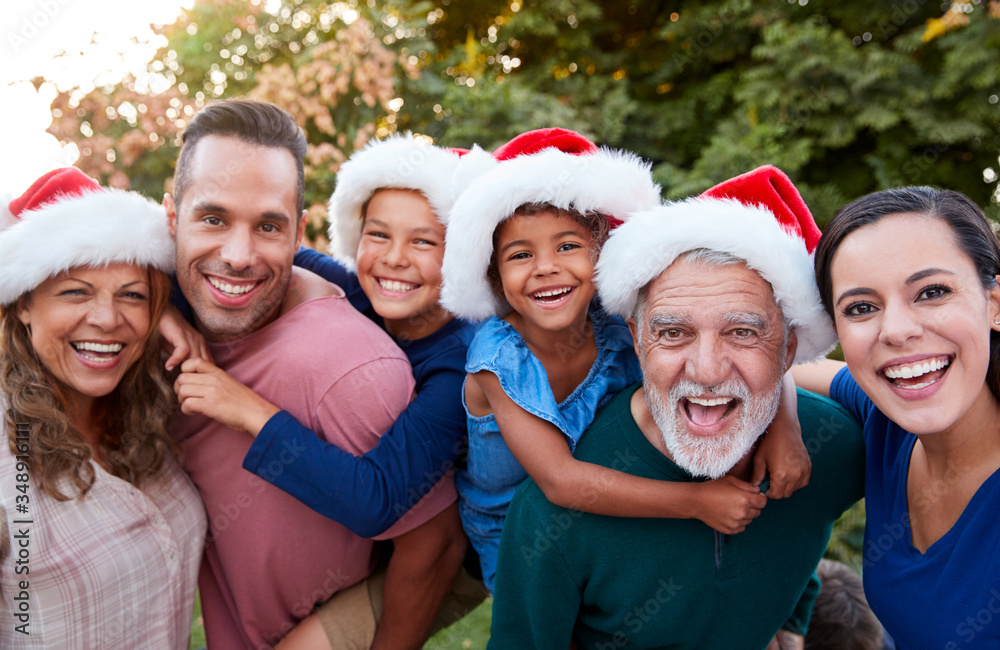 Portrait Of Multi-Generation Hispanic Family Relaxing In Garden At Home Together At Christmas Portrait Of Multi-Generation Hispanic Family Relaxing In Garden At Home Together At Christmas