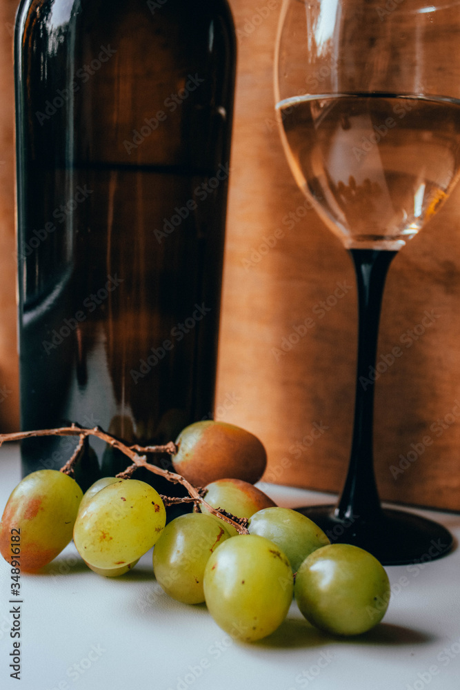 Bottle of wine, glass and grapes on a wooden background Bottle of wine, glass and grapes on a wooden background