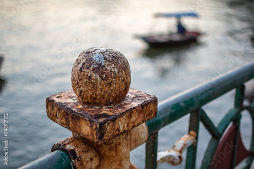 Rusty railing with blurred fisher boat in background Vietnam Catba Island