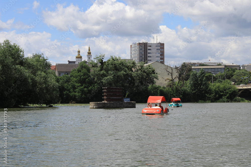 People ride catamarans on the river