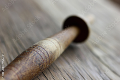 an old knitting spindle on a structural table made of cracked wood