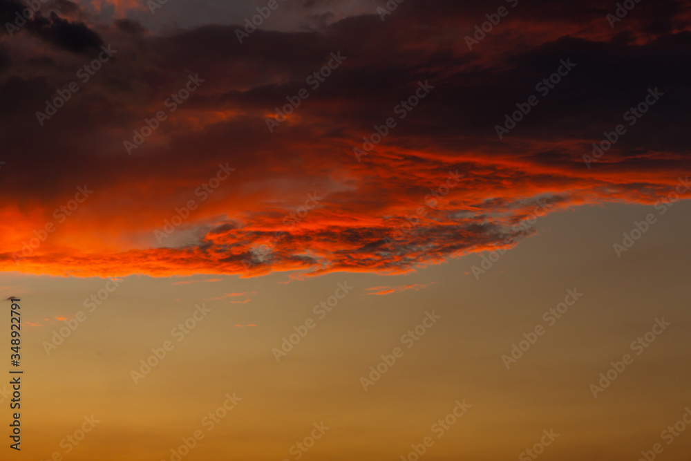 Black thunderclouds at sunset. Bright orange sunset and dark clouds. Storm sky