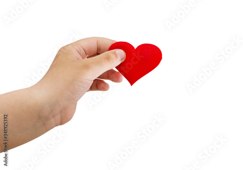 Child's hand holds a red heart isolated on a white background.