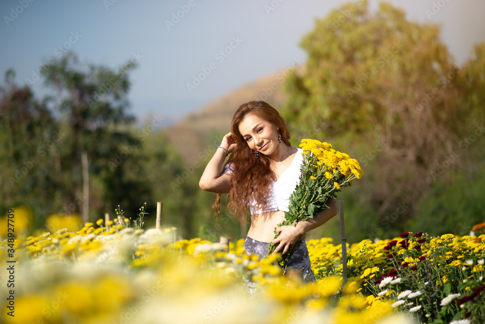 Portrait beautiful asian woman in white dress relaxing at chrysanthemum garden Portrait beautiful asian woman in white dress relaxing at chrysanthemum garden