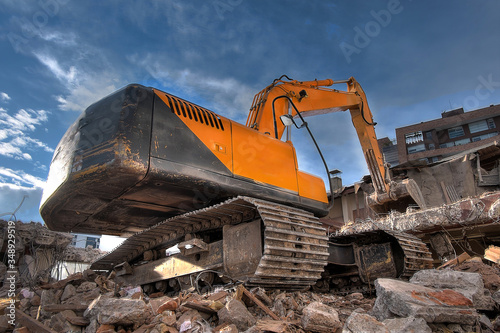 Demolition bulldozer tearing down a house