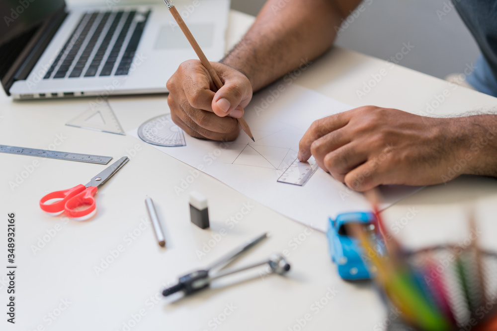Work from home concept. Close up male hands is painting picture with pencil in the paper on white table. Work from home concept. Close up male hands is painting picture with pencil in the paper on white table.
