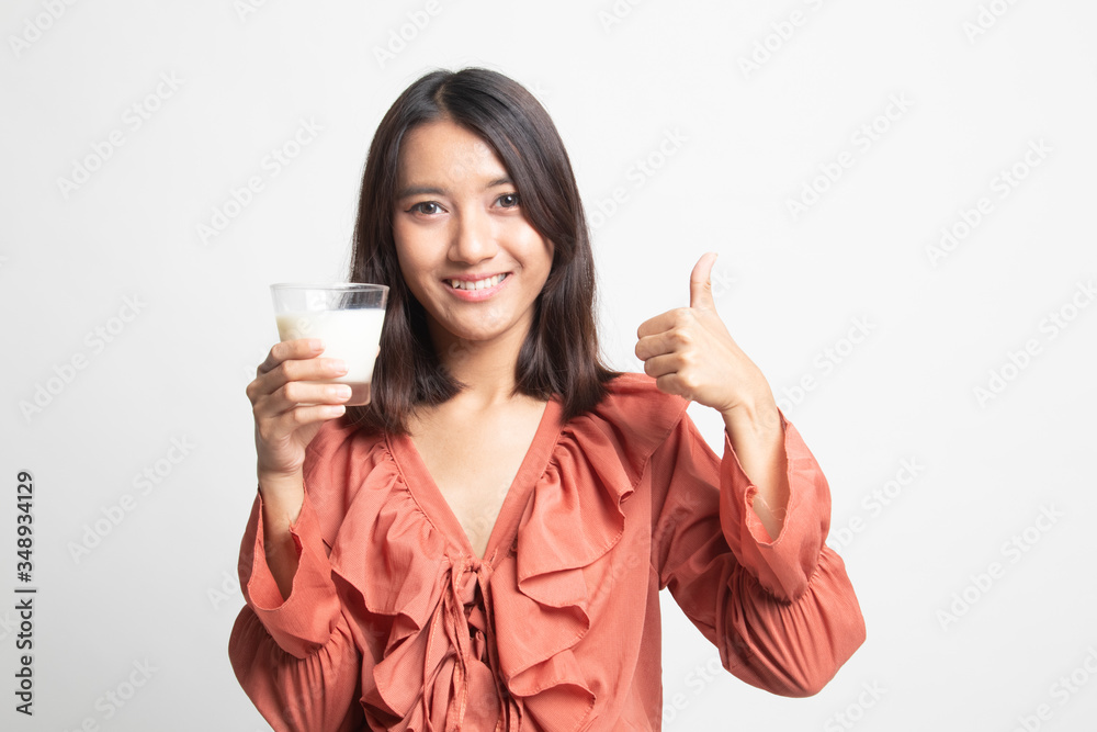 Healthy Asian woman drinking a glass of milk thumbs up . Healthy Asian woman drinking a glass of milk thumbs up .