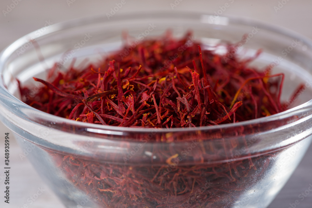 Fototapeta premium Close up on spice glass with red saffron on cutting board