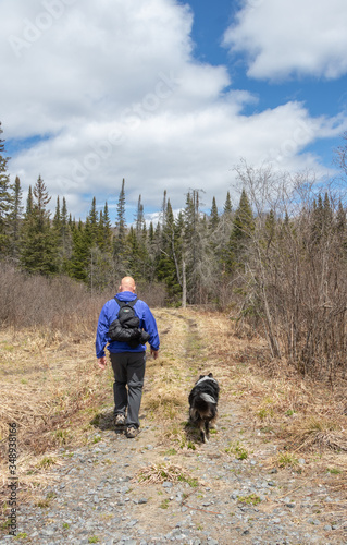 A man hiking with his dog through a park in Ontario in spring