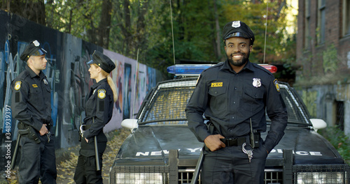 Fotografie Happy and smiling African American police officer looking at camera