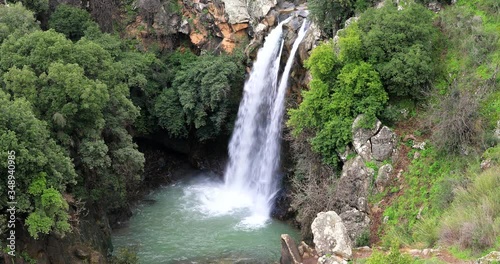 High waterfall and greenery all around.