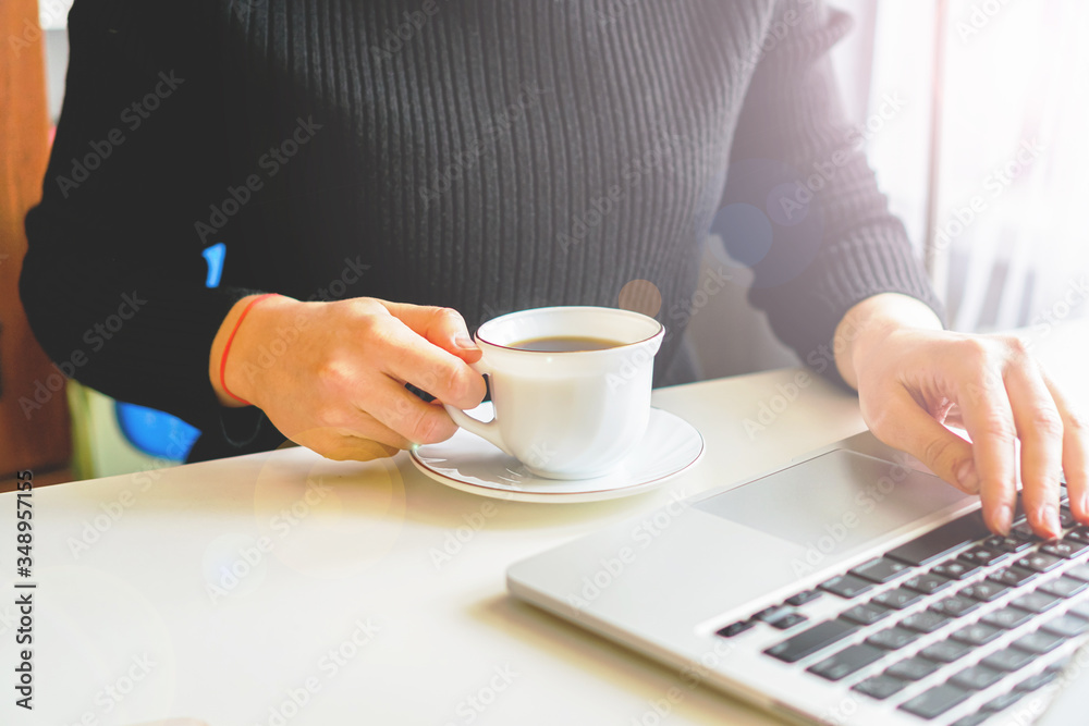 girl typing on a laptop keyboard, next is a mug of coffee girl typing on a laptop keyboard, next is a mug of coffee