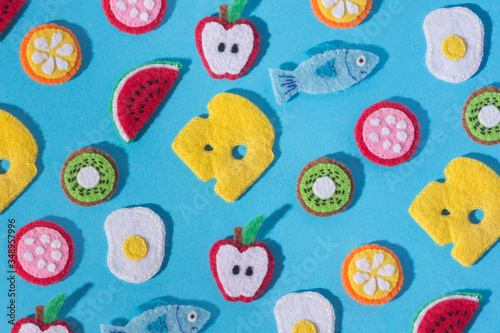 Toys in the form of food and fruits hand made of felt on blue background. Hand sewing