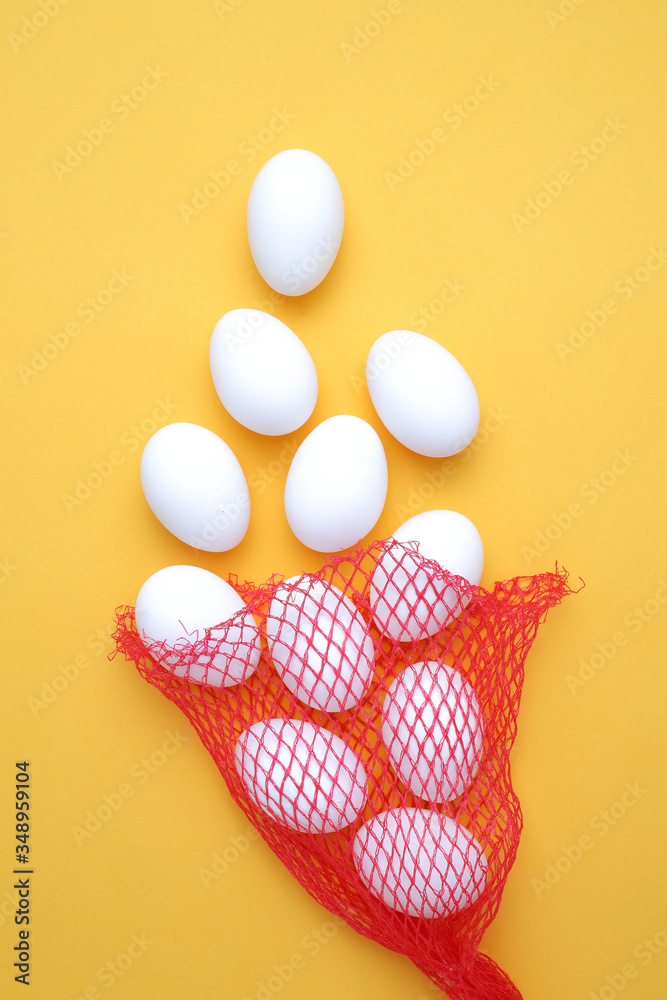 Eggs,Eggs come out of the net red bag.top view yellow background easter egg