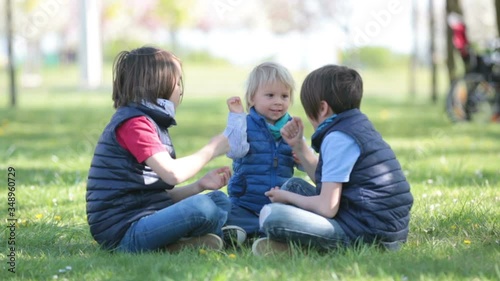 Wallpaper Mural Three children, boy brothers, playing rock scissors paper game in park Torontodigital.ca
