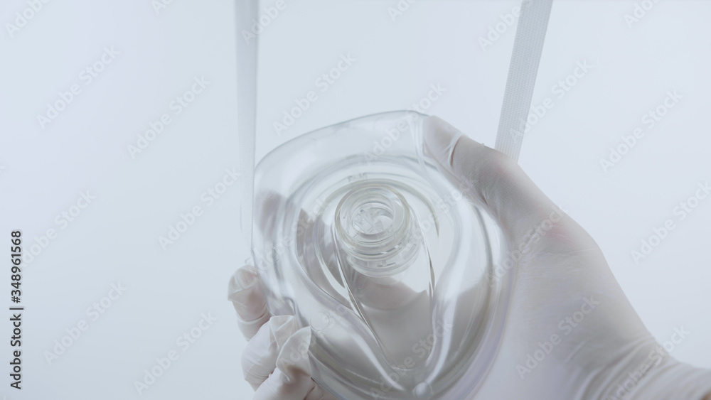 Putting on oxygen mask. White surgical gloves in sterile environment Putting on oxygen mask. White surgical gloves in sterile environment