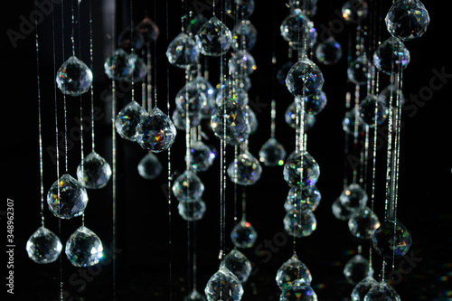 Fényképezés Brightly lit crystals hanging from wire in a constellation