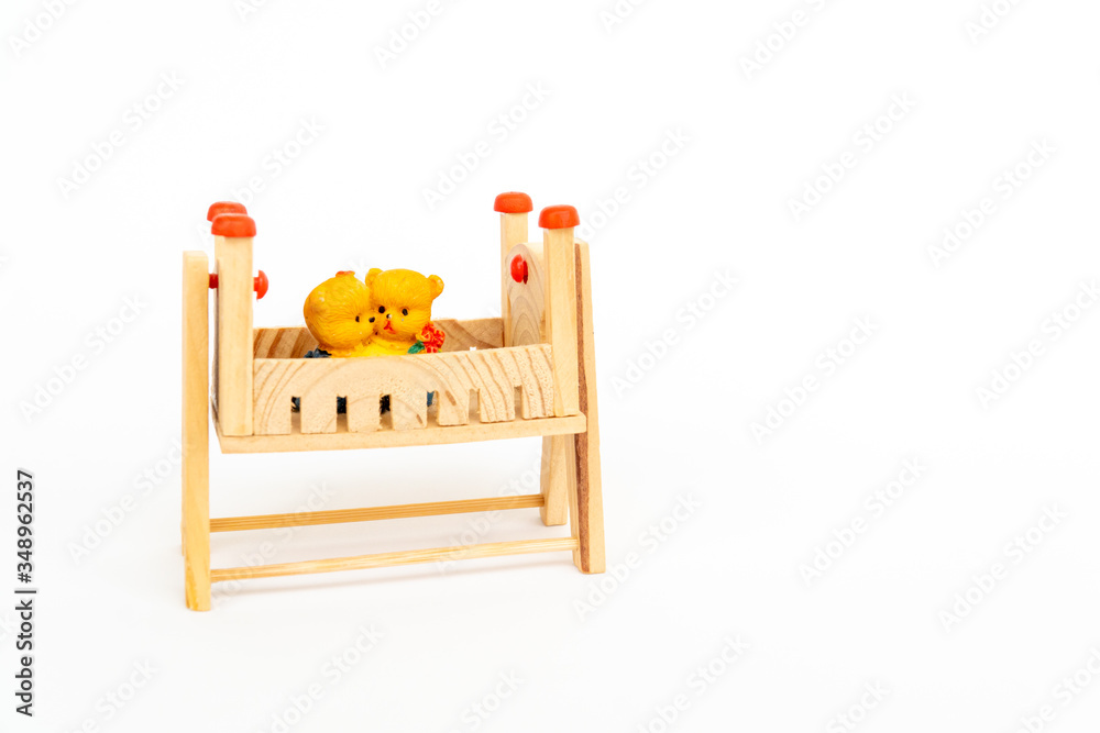 Toy teddy bears sit toy beds. Toy wooden bed. Wooden toy bed with a cute pair of teddy bears. Cute wooden decor
