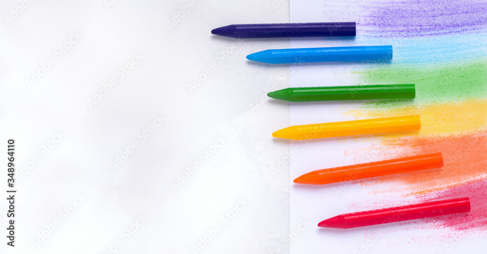 The concept of drawing lessons. Crayons of different colors on a white background. Copy space The concept of drawing lessons. Crayons of different colors on a white background. Copy space