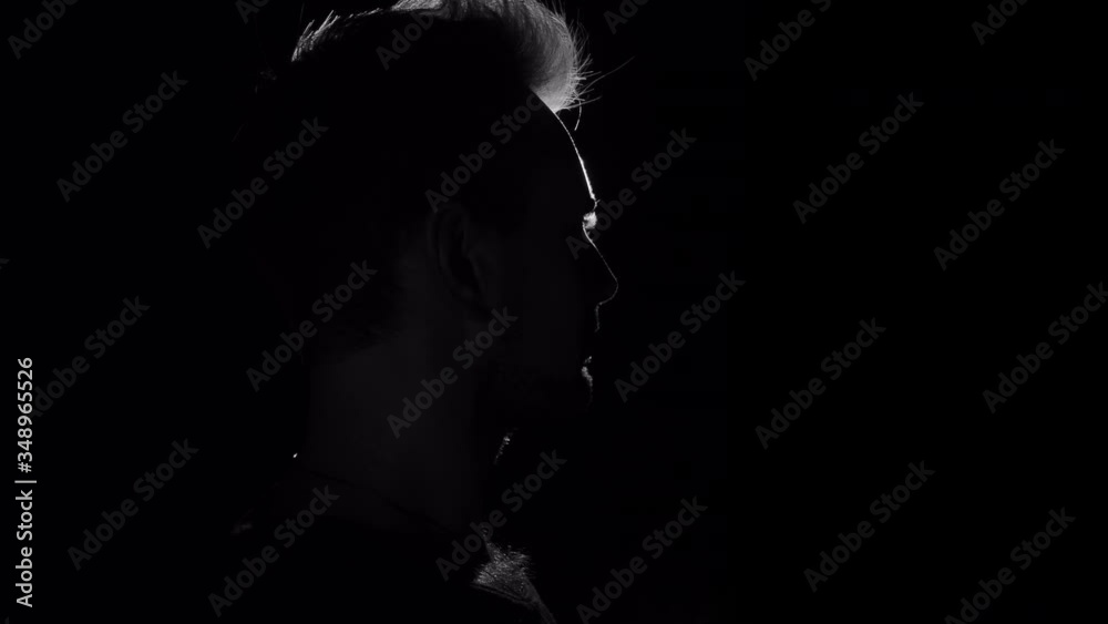 Silhouette profile portrait of hiding in shadow male person on dark background