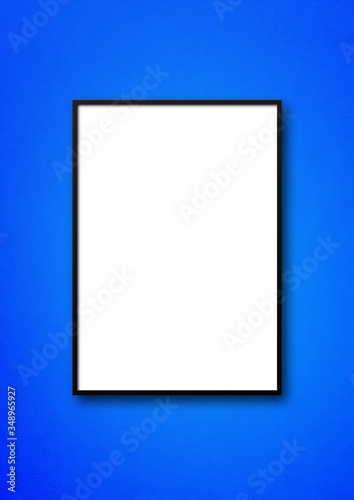 Black picture frame hanging on a blue wall