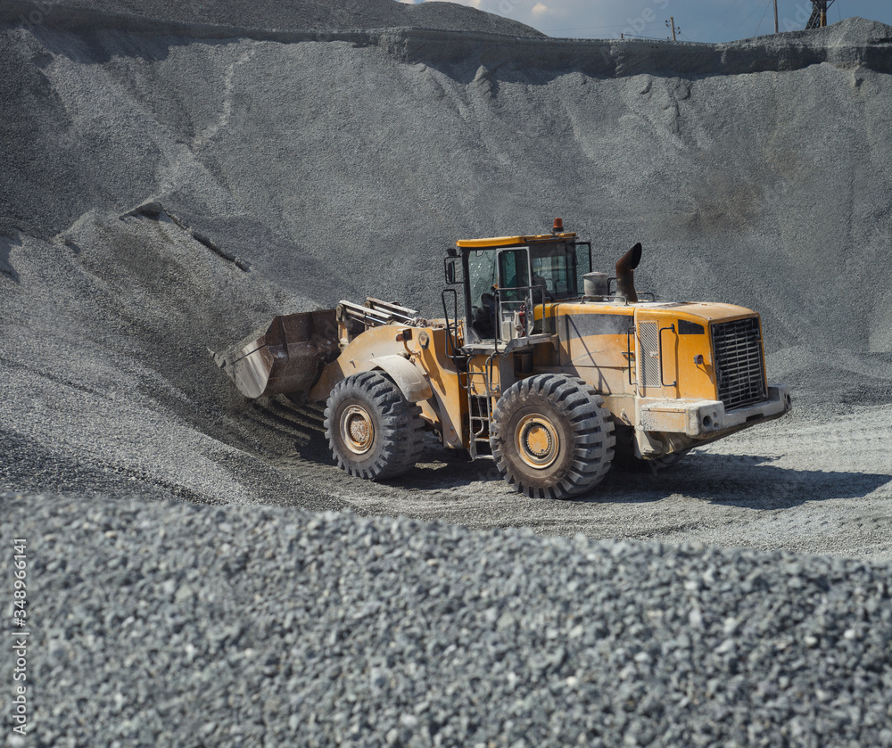 Front-end loader in a limestone quarry, close-up. Front-end loader in a limestone quarry, close-up.
