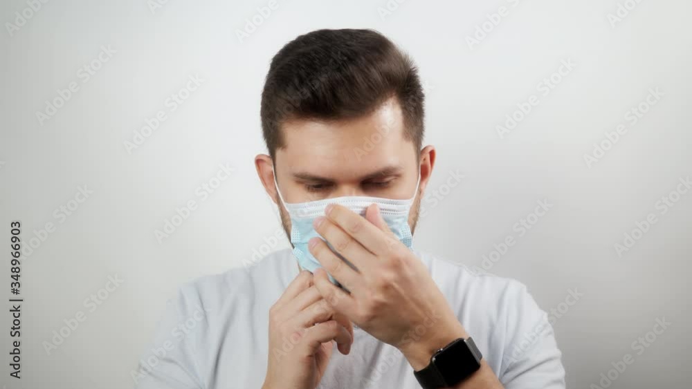Happy positive man takes off protective medical mask from face, smiling. Happy end quarantine and home isolation. Victory over coronavirus. Pandemic Covid-19. Happy positive man takes off protective medical mask from face, smiling. Happy end quarantine and home isolation. Victory over coronavirus. Pandemic Covid-19.