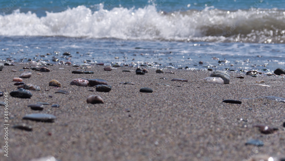 Bright sunny afternoon at the beach with shinny stones and beautiful blue ocean Bright sunny afternoon at the beach with shinny stones and beautiful blue ocean