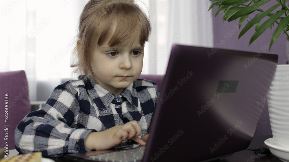 Girl learning online lessons using digital laptop computer. Distance education