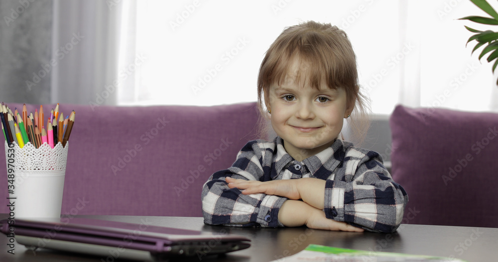 Girl sitting on table at home. Studying online homework. Distance education Girl sitting on table at home. Studying online homework. Distance education