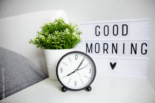 Photography good morning concept - close up of alarm clock, houseplant and lightbox with go