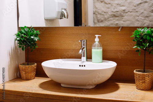 Close up of a wash basin and liquid soap in a modern restroom