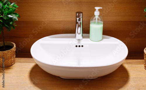 Close up of a wash basin and liquid soap in a modern restroom